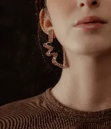 Par de aros colgantes con forma geométrica irregular, recubiertos de strass negros sobre base plateada.