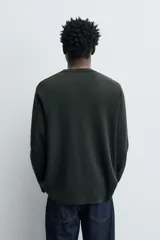 Jersey de punto fino confeccionado en hilatura de lana, con cuello redondo, manga larga y acabados en rib.