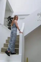 Vestido largo azul con estampado geométrico, tirantes finos y detalles de ribetes oscuros que marcan las costuras.