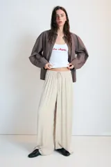 Pantalón de tiro medio, color negro, confeccionado en tejido satinado con diseño de pierna ancha y cintura elástica ajustable con cordón.