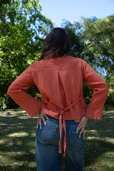 Camisa color ladrillo de muselina, corte amplio, cuello con volados y botones frontales.