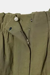 Bermuda color verde militar de tiro alto con cintura elástica y cinturón marrón con abalorios. Presenta bolsillos laterales ocultos y cierre frontal con cremallera y gancho metálico.