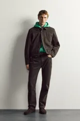 Cazadora cropped fit marrón de denim de algodón, con cuello solapa, manga larga con puño abotonado, bolsillo de parche en el pecho, pliegues verticales en el delantero y cierre frontal con botones.