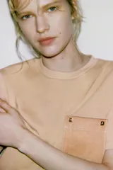 Camiseta blanca de algodón, corte regular, cuello redondo y manga corta, con bolsillo cuadrado de tejido efecto piel color camel en el pecho.