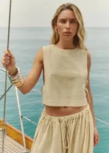 Top corto color beige de bambula con escote redondo, sisas amplias y tiras laterales para atar.