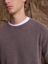 Sweater de punto en color azul marino, con cuello redondo y mangas raglán. Presenta un tejido acanalado fino y puños elásticos.