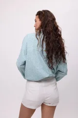 Short de corte sastrero color turquesa, con cierre frontal de botón y bolsillos laterales.