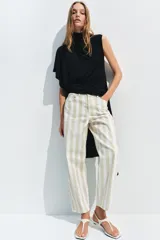 Jeans de tiro medio con corte tapered, diseño de cinco bolsillos y cierre frontal con cremallera y botón. Presenta un estampado de rayas verticales a contraste en tonos claros.