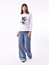 Remera de manga larga color beige, con cuello redondo y estampado frontal que dice "Magic is something you make" en color lila.