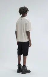 Remera de tejido de punto color beige con moldería ligeramente oversize, cuello redondo y mangas cortas. Confeccionada en una mezcla de viscosa y poliéster que ofrece una caída fluida y textura suave.
