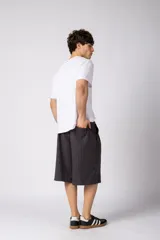 Bermuda sastrera baggy de color negro con diseño de rayas diplomáticas finas blancas. Cuenta con bolsillos laterales y presillas para cinturón.