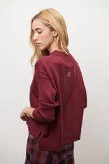 Buzo de punto color beige, con cuello redondo y manga larga.