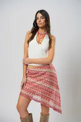 Minifalda asimétrica de crochet con diseño de ondas en tonos rojo, rosa y beige.