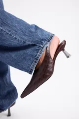 Zapato destalonado de cuero vacuno con textura efecto cocodrilo, diseño de punta fina y taco bajo.