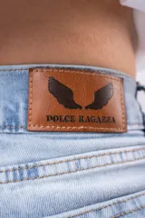 Jeans de mezclilla azul claro, tiro alto, corte wide leg y roturas a la altura de las rodillas.