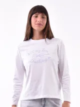 Remera de manga larga color crema con cuello redondo y un estampado central de un ramo de flores rosadas y naranjas en un jarrón azul oscuro.