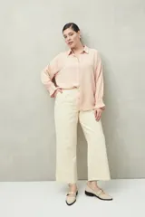 Camisa negra de manga larga con cuello clásico y botones frontales. El tejido presenta una textura arrugada o plisada, y los puños tienen un frunce elástico.