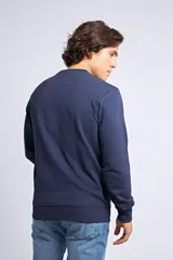 Buzo clásico de cuello redondo y manga larga, en color gris melange. Presenta un ajuste regular y un logo bordado con detalle en goma en el pecho.