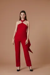 Mono largo negro de corte elegante, con escote halter y detalle de herraje metálico dorado en el cuello. Presenta una silueta entallada en el torso y pantalón de corte recto con pinzas frontales.