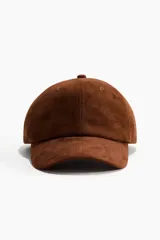 Gorra marrón de textura gamuzada con ojales bordados y visera curva, ajustable en la parte trasera.