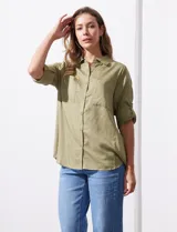 Camisa color verde oliva de lyocell, marca Cyrus. Tiene cuello con solapa, abertura central con botones, mangas 3/4 regulables con presilla y botón, y dos bolsillos delanteros aplicados.
