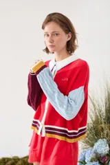Cardigan de punto con diseño tricolor, de corte relajado, manga larga de tejido trenzado en contraste de color, cuello solapa tipo polo y cierre frontal de botones.