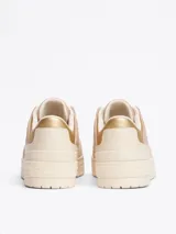 Zapatillas Tommy Hilfiger color crema y rosa pálido, con detalles dorados en el talón y logo de la marca en el lateral.