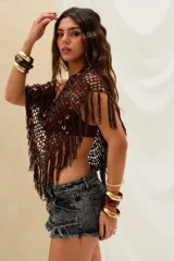 Top corto tejido al crochet en color marrón, con diseño de red adornado con lentejuelas circulares distribuidas por toda la prenda y flecos colgantes en el ruedo.
