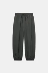 Pantalón de tiro medio y cintura elástica con cordón de ajuste, bolsillos laterales y bajo abullonado con puños elásticos. Confeccionado en poliamida.