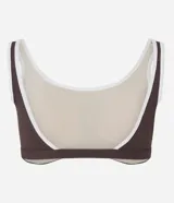 Top deportivo de microfibra con escote redondo delantero y escote en V en la espalda. Presenta un diseño bicolor con cuerpo en color crema y ribetes en color marrón oscuro, breteles anchos y copas desmontables.