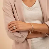 Brazalete tipo esclava de alambre redondo en plata 925, con dije de medalla circular colgante.