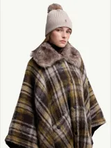 Gorro de lana tejido en punto acanalado, color beige claro, con pompón de pelo en la parte superior. Presenta un pequeño logo bordado en la parte frontal.