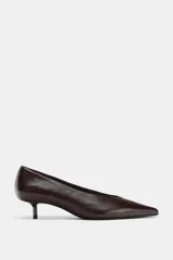 Zapato de piel color marrón oscuro (casi negro), con punta fina y tacón bajo tipo kitten de 4 cm.