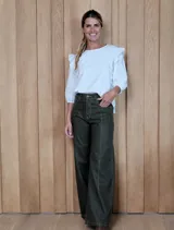 Pantalón de jean ancho con costuras verticales decorativas en el frente y pespuntes en contraste. Presenta un diseño de tiro medio con bolsillos laterales y ruedo desflecado.