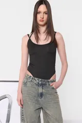 Body negro de microfibra, corte ajustado, con escote redondo y breteles finos. Presenta tiras cruzadas en la espalda y broches a presión en la entrepierna.