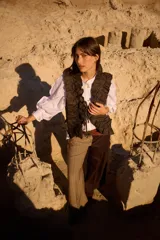 Chaleco de tweed con diseño estructurado y volados decorativos en lino. Presenta un cierre frontal con cintas para atar y un corte entallado.