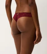 Conjunto de lencería compuesto por un corpiño tipo bralette con aros y una bombacha tipo bikini, ambos confeccionados en encaje con diseño geométrico en color bordó.