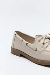 Zapato náutico de cuero sintético color marrón, con cordones decorativos, costuras a la vista y suela de goma antideslizante.