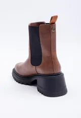 Bota marrón de símil cuero, con punta redondeada, pieza elastizada negra en los laterales y plataforma de 6cm.