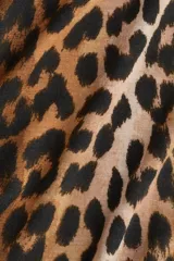 Top de punto con cuello alto y manga larga, con diseño de estampado de leopardo y terminaciones con remate sobrehilado en puños y bajo.