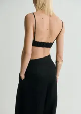 Top negro con tirantes finos, diseño crop y lazo en el frente.