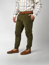 Pantalón de pana negro de corte recto, con bolsillos laterales y traseros. Se ajusta a la cintura con cinturón de cuero negro.