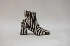 Botas plateadas de cuero con caña media, cierre lateral con cremallera, punta cuadrada y tacón geométrico de madera.