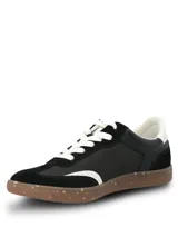 Championes urbanos de diseño deportivo en color negro, con paneles de gamuza sintética y material textil. Presentan detalles en blanco en el talón, cordones y borde frontal, con suela de goma tipo caramelo con efecto moteado.
