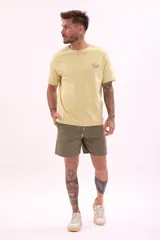 Remera de manga corta color amarillo pálido con cuello redondo y un pequeño estampado gráfico en el pecho.