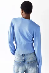 Saco corto de punto fino en mezcla de viscosa color celeste, con cuello en V, cierre frontal de botones y diseño entallado con detalles acanalados en los puños y el bajo.