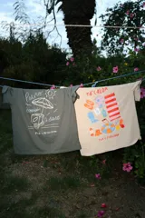 Remera oversize color gris oscuro con estampa frontal en tonos claros que incluye un carrito de helados, una sombrilla y el texto 'Palito Bombón Helado' junto a la firma de la colaboración Pica x Petrichor.