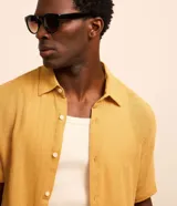 Camisa de hombre de manga corta, cuello inglés y calce comfort, confeccionada en algodón texturado de color verde oliva.