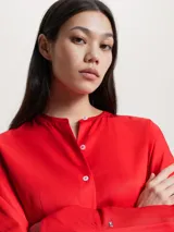 Vestido camisero rojo de viscosa, corte recto, largo hasta la rodilla, con cuello mao, cierre frontal con botones y cinturón de lazo.