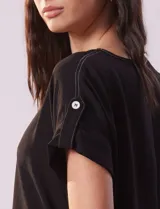 Blusa negra de gasa con cuello a la base y mangas cortas con presilla y botón.